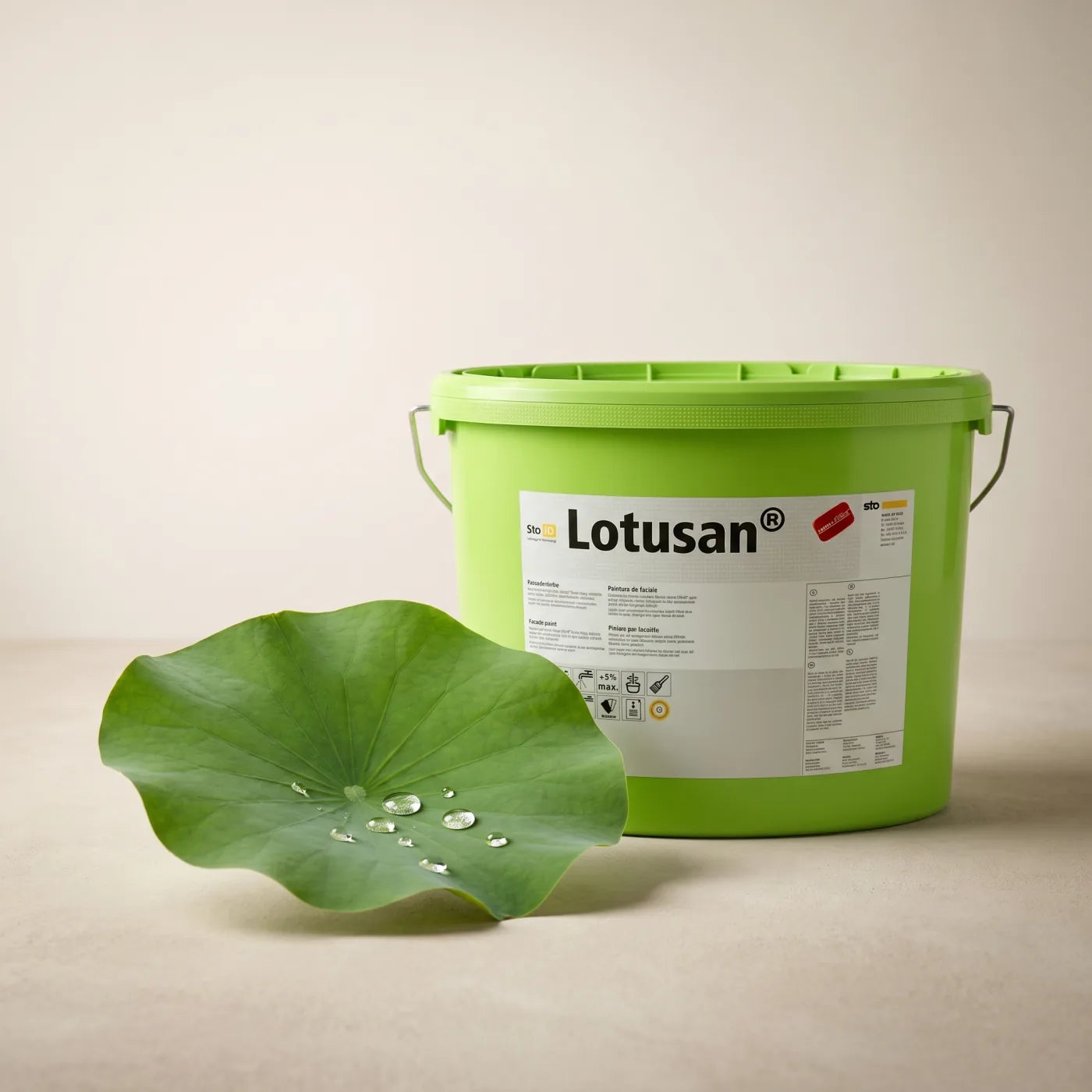 StoColor Lotusan Eimer neben echtem Lotusblatt mit Wassertropfen
