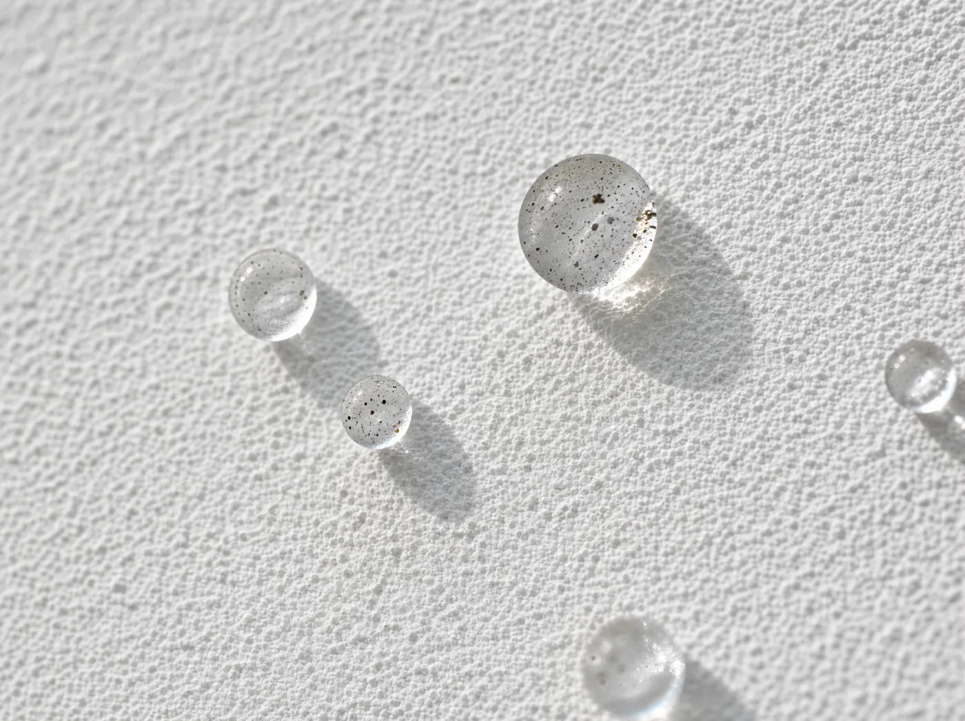 Wassertropfen perlen auf Lotusan-Fassade ab — Lotus-Effect Makroaufnahme