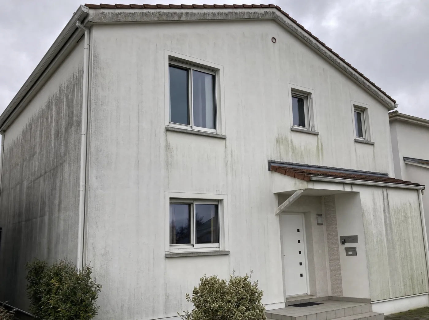 Verwitterte Standard-Acrylat-Fassade nach 5 Jahren — Algen, Streifen, vergraute Wetterseite