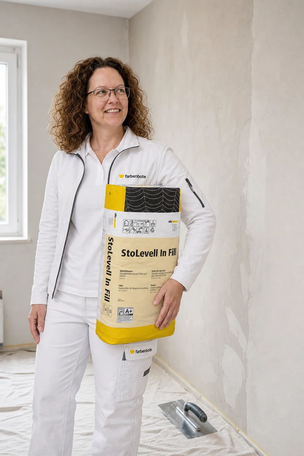 Jessica vom Farbenbote-Team mit StoLevell In Fill beim Füllen einer Innenwand
